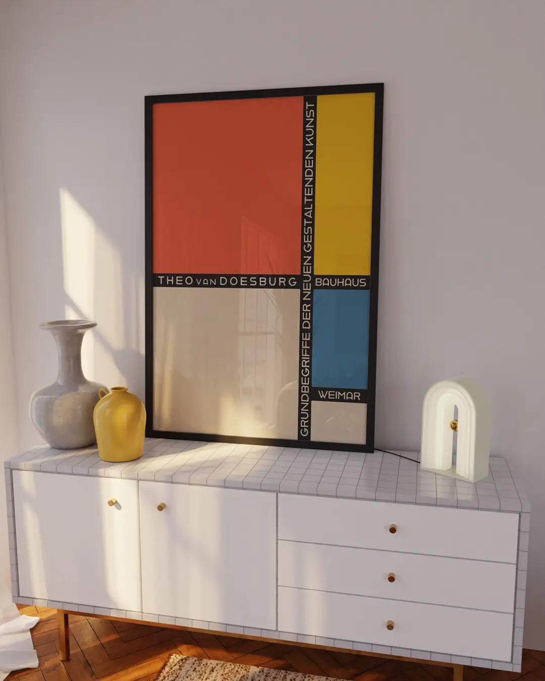 テレビボードの上に飾られたブラックフレームのバウハウス・パッチワークポスター。幾何学的な構成と配色が際立つモダンアートポスター。